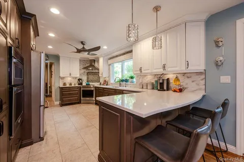 a kitchen with kitchen island a stove a table and chairs in it