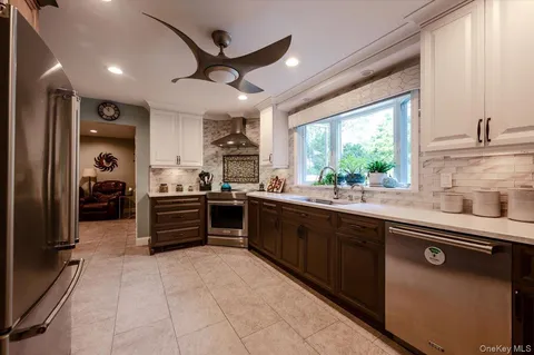 a kitchen with stainless steel appliances kitchen island granite countertop a sink counter space cabinets and a large window