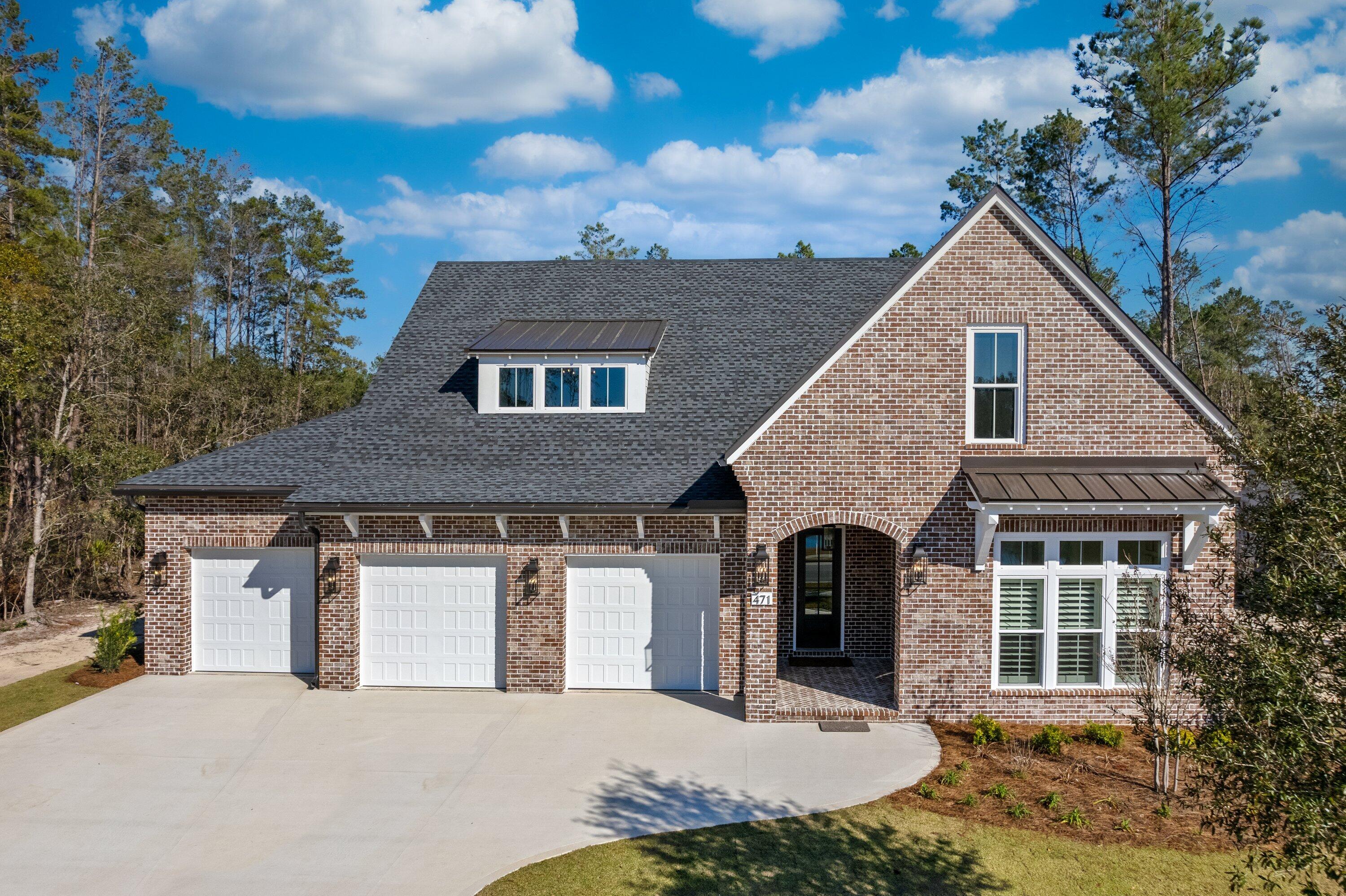 a front view of a house with garage and trees