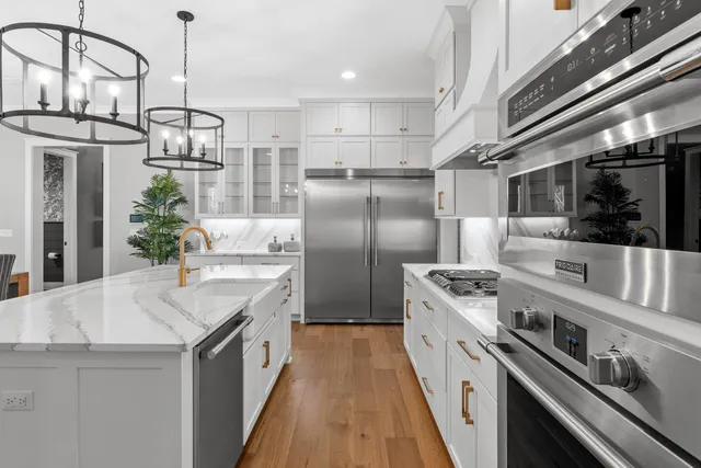 a kitchen with stainless steel appliances granite countertop a sink a stove and a refrigerator