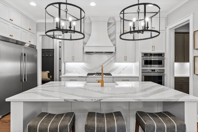 a kitchen with stainless steel appliances a table chairs and chandelier
