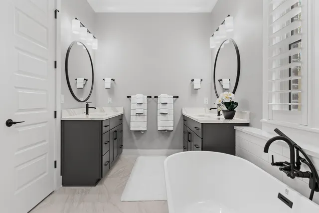 a en suite bathroom with a double vanity sink and a mirror