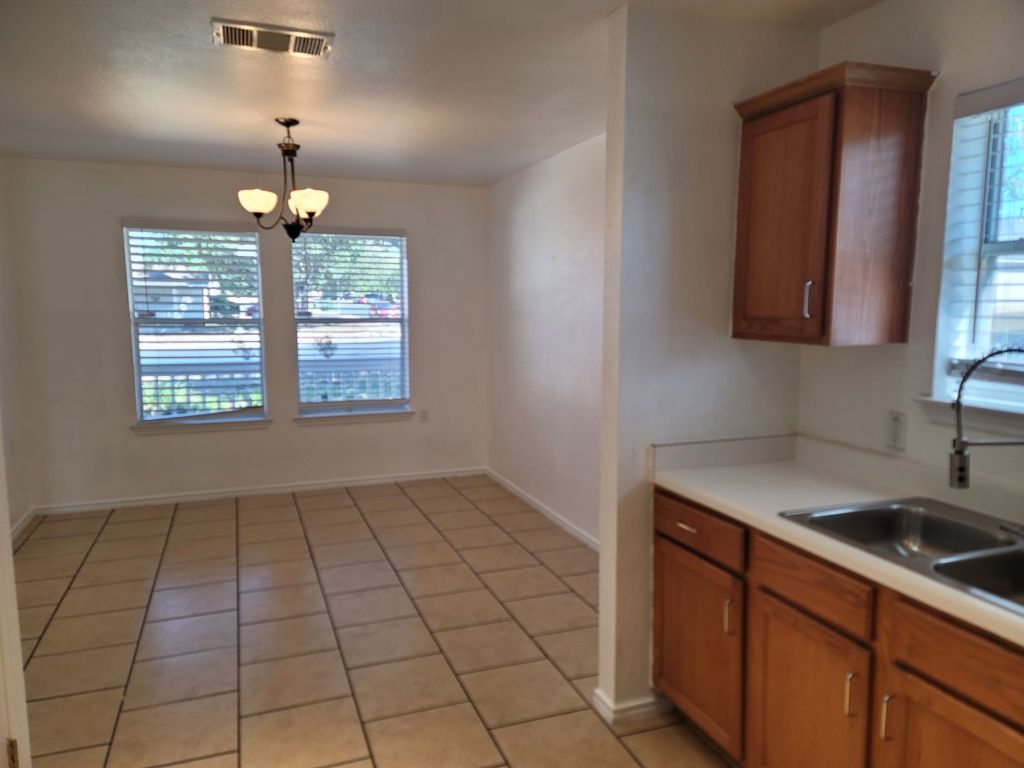 707 Windledge Drive Austin, TX 78745 - Photo 12 of 25 a kitchen that has a sink a window and cabinets