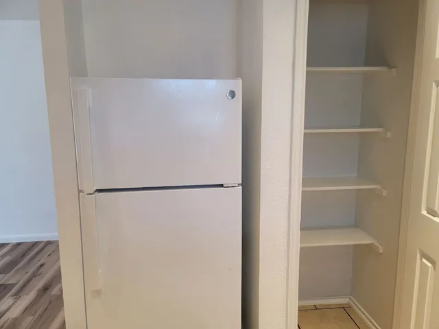 a white refrigerator freezer sitting next to a white cabinet