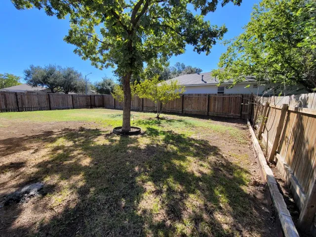 a view of a yard with wooden fence