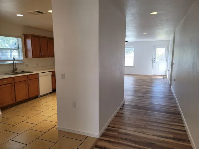 a view of a hallway with wooden floor and staircase