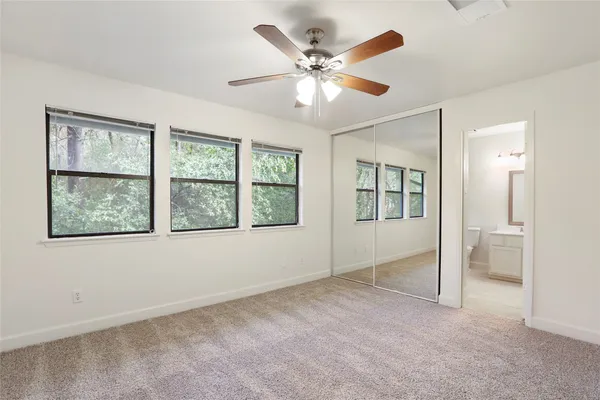 an empty room with fan and windows