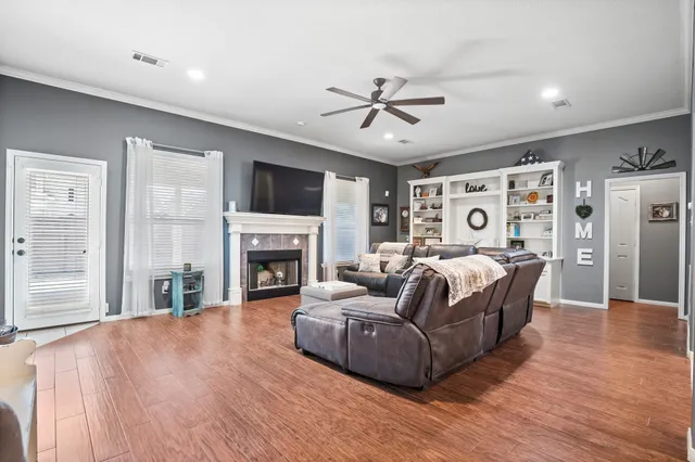a living room with furniture a fireplace and a flat screen tv