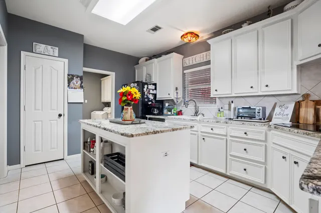 a kitchen with white cabinets and appliances