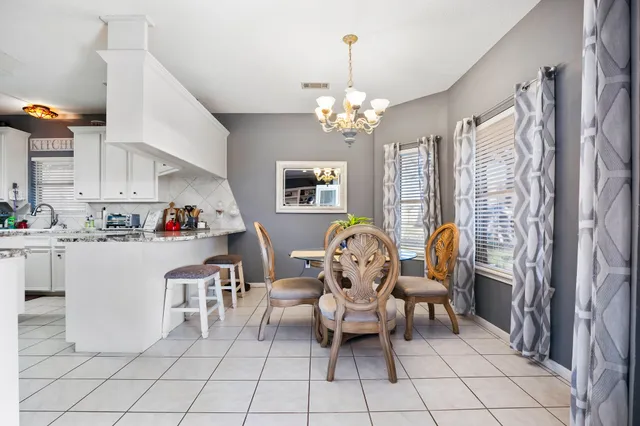 a living room with patio furniture and a chandelier
