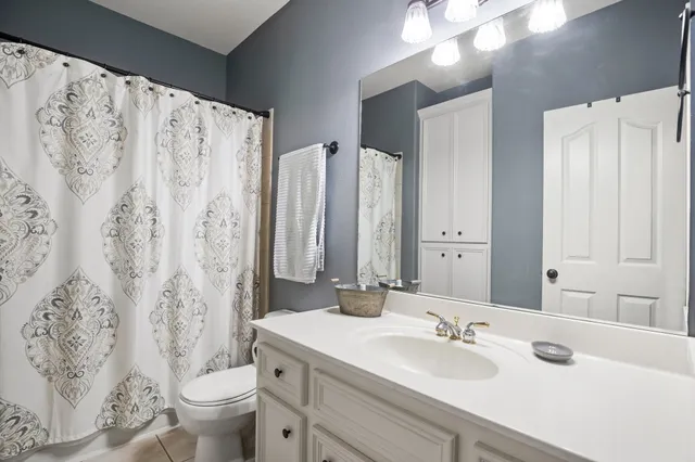 a bathroom with double vanity sink toilet and a mirror