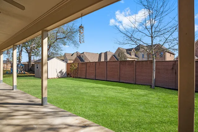 a view of a backyard with large trees and plants