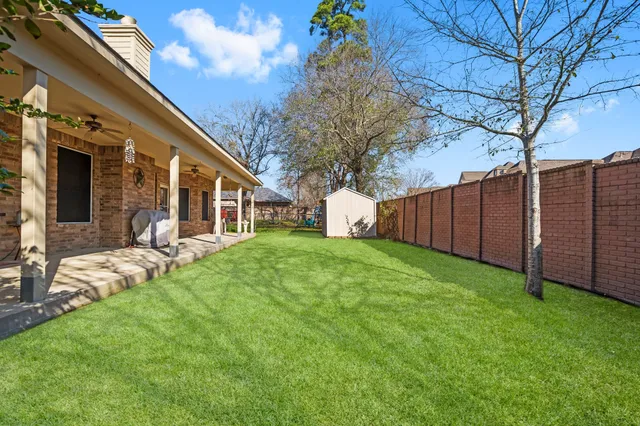 a view of a house with backyard and a tree