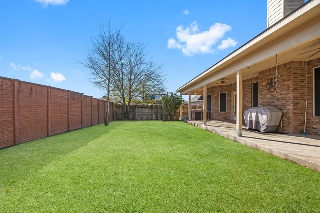 a view of a backyard with table and chairs and a barbeque with potted plants