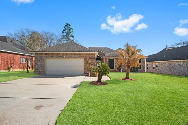 a view of a house with a backyard and a tree