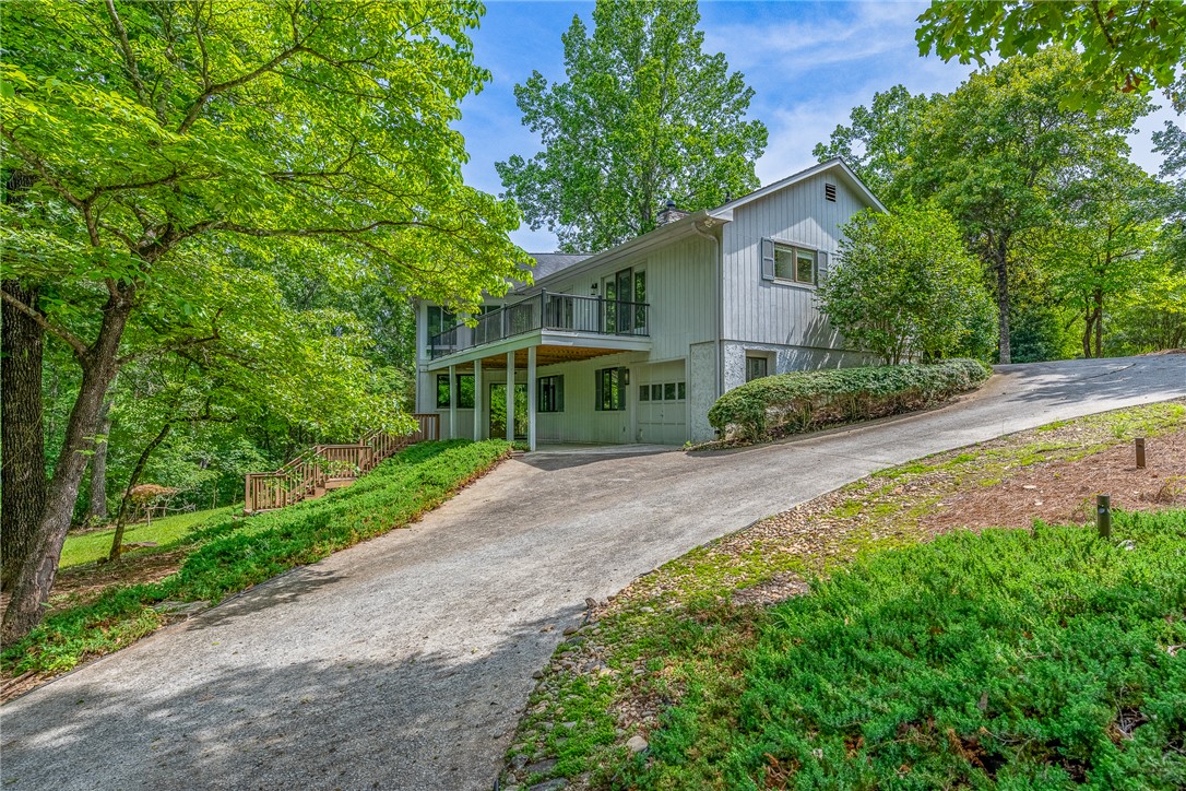 118 Beacon Ridge Circle Salem, SC 29676 - Photo 34 of 45 A private driveway ascends to a secluded modern residence nestled amidst a lush, verdant landscape.