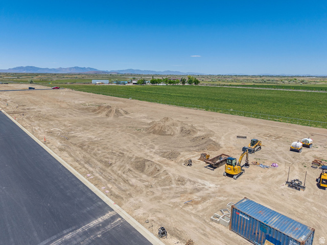 3187 South 5250 West, Unit 212 Hooper, UT 84315 - Photo 2 of 10 Expansive cleared parcel featuring graded earth, a new asphalt road with a concrete curb, and a distant mountain range