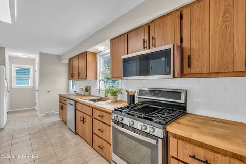a kitchen with stainless steel appliances granite countertop a stove a sink and a microwave