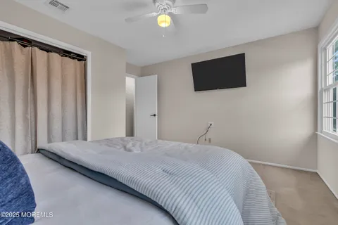 a bedroom with a bed tv and a window