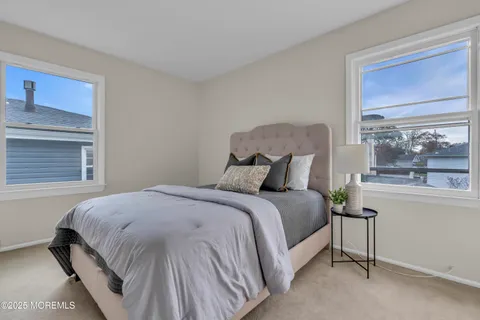 a large bed sitting in a bedroom next to a window