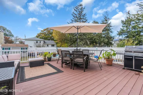 an outdoor sitting area with furniture and wooden floor