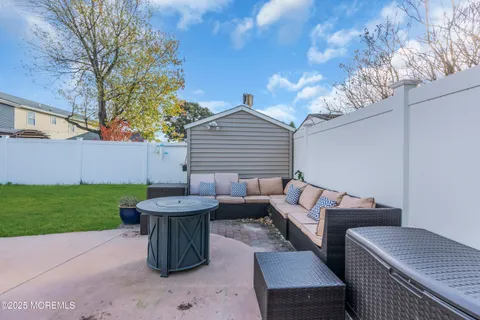 a view of a patio with couches table and chairs with plants and trees