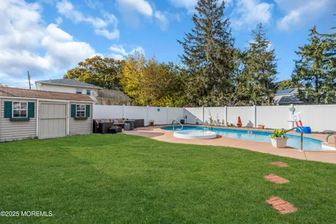 a view of a backyard with table and chairs and a barbeque with potted plants and big trees
