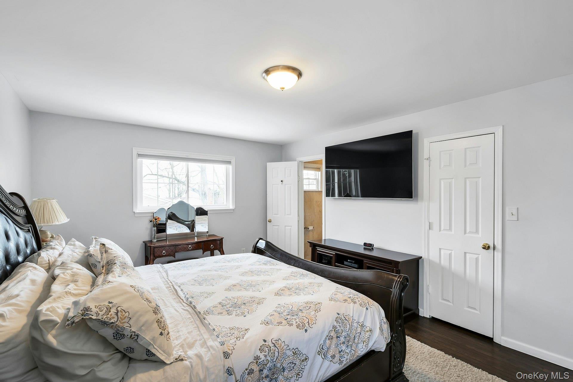 2043 Ripley Lane Merrick, NY 11566 - Photo 23 of 42 a bedroom with a bed and a flat screen tv