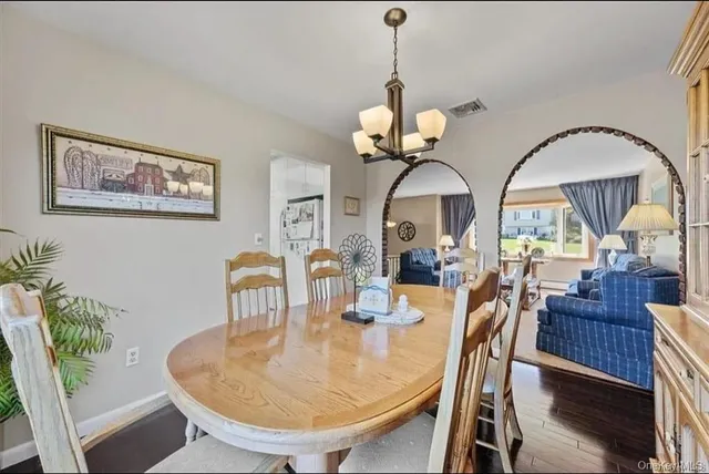 a view of a dining room with furniture a chandelier and wooden floor