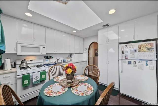 a kitchen with stainless steel appliances granite countertop a dining table cabinets and a refrigerator