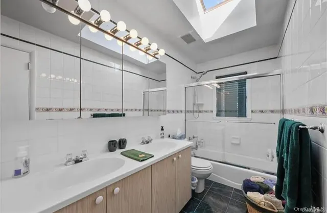 a bathroom with a double vanity sink toilet and shower