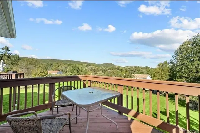 a view of a balcony with mountain view and wooden floor