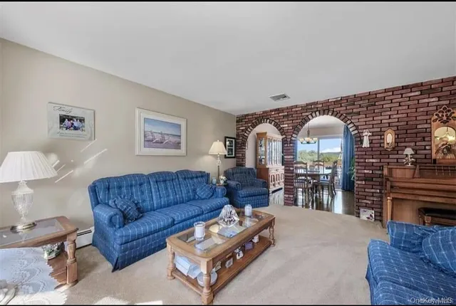 a living room with furniture a rug and a large window