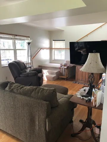 a living room with a bed furniture and a large window