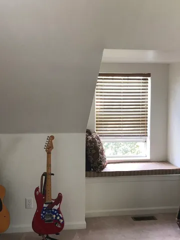 a view of lake from a balcony with large trees