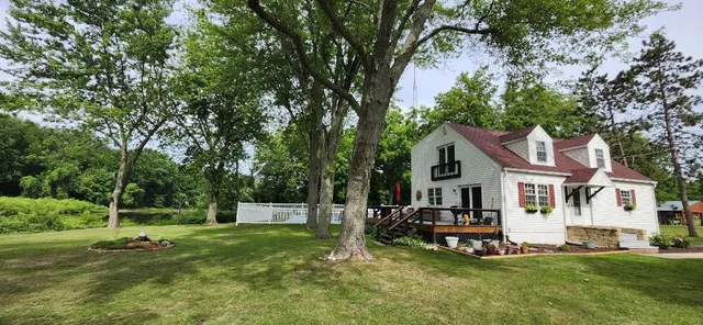 a backyard of a house with a yard and large trees