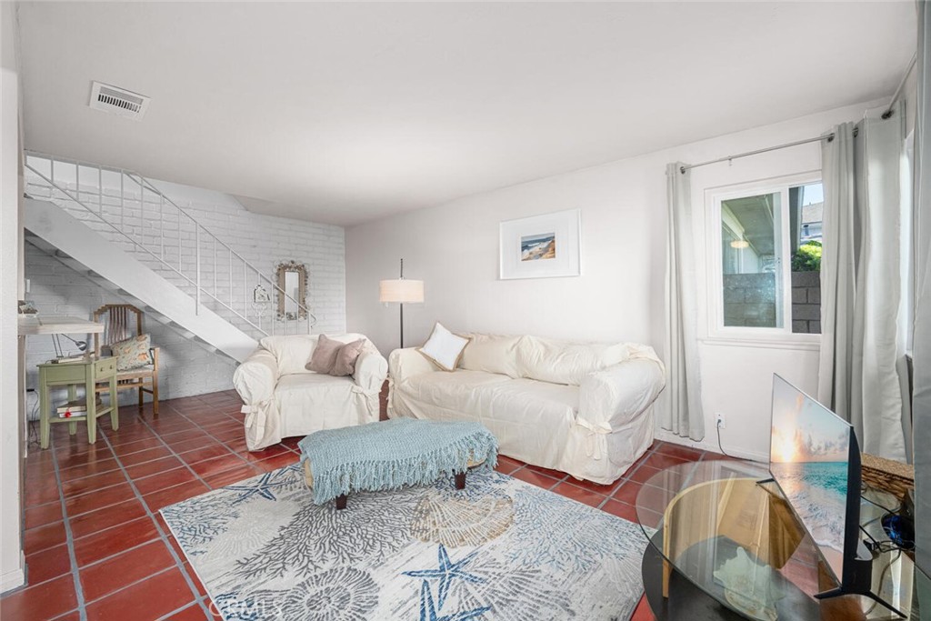 16393 Del Oro Circle, Unit 123 Huntington Beach, CA 92649 - Photo 1 of 24 a living room with furniture and wooden floor