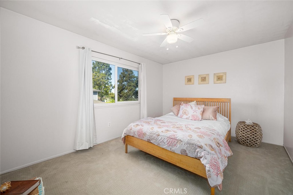 16393 Del Oro Circle, Unit 123 Huntington Beach, CA 92649 - Photo 12 of 24 a bedroom with a bed and a chandelier