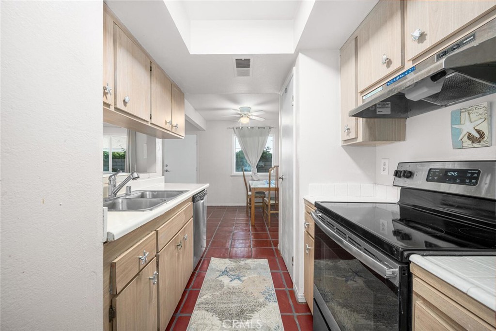 16393 Del Oro Circle, Unit 123 Huntington Beach, CA 92649 - Photo 9 of 24 a kitchen with a sink stove and cabinets
