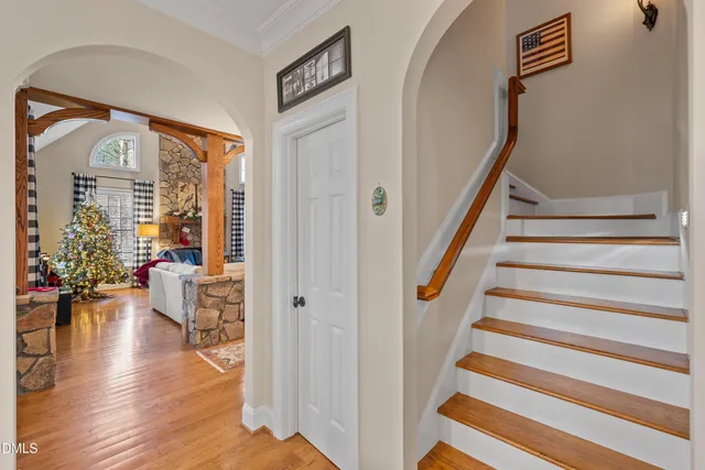 a view of a hallway with wooden floor and staircase