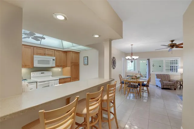 a dining hall with stainless steel appliances a dining table and chairs with wooden floor