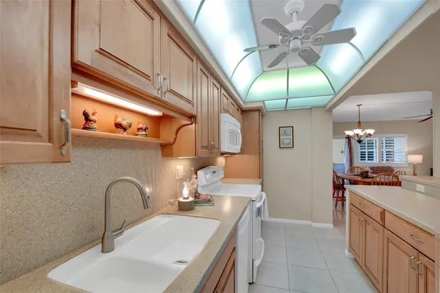 a kitchen with stainless steel appliances granite countertop a sink a stove top oven a chimney and cabinets