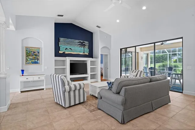 a living room with furniture a flat screen tv and a kitchen view