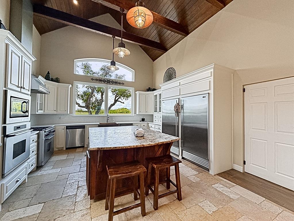 909 Higginbotham Lane China Spring, TX 76633 - Photo 5 of 40 a kitchen with stainless steel appliances granite countertop a stove a refrigerator and a dining table view