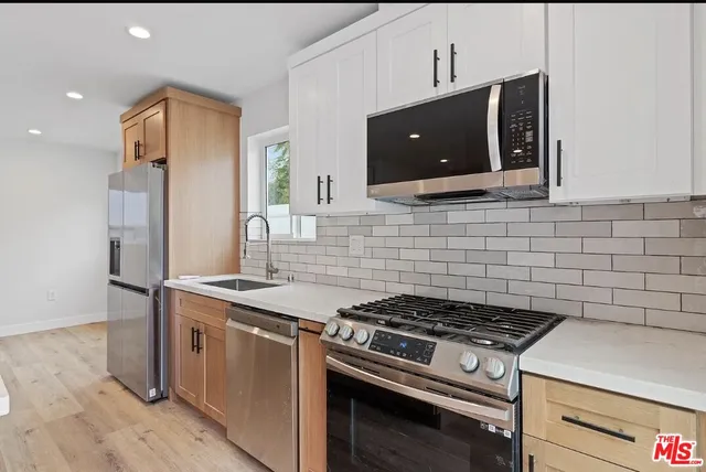 a stove top oven sitting inside of a kitchen
