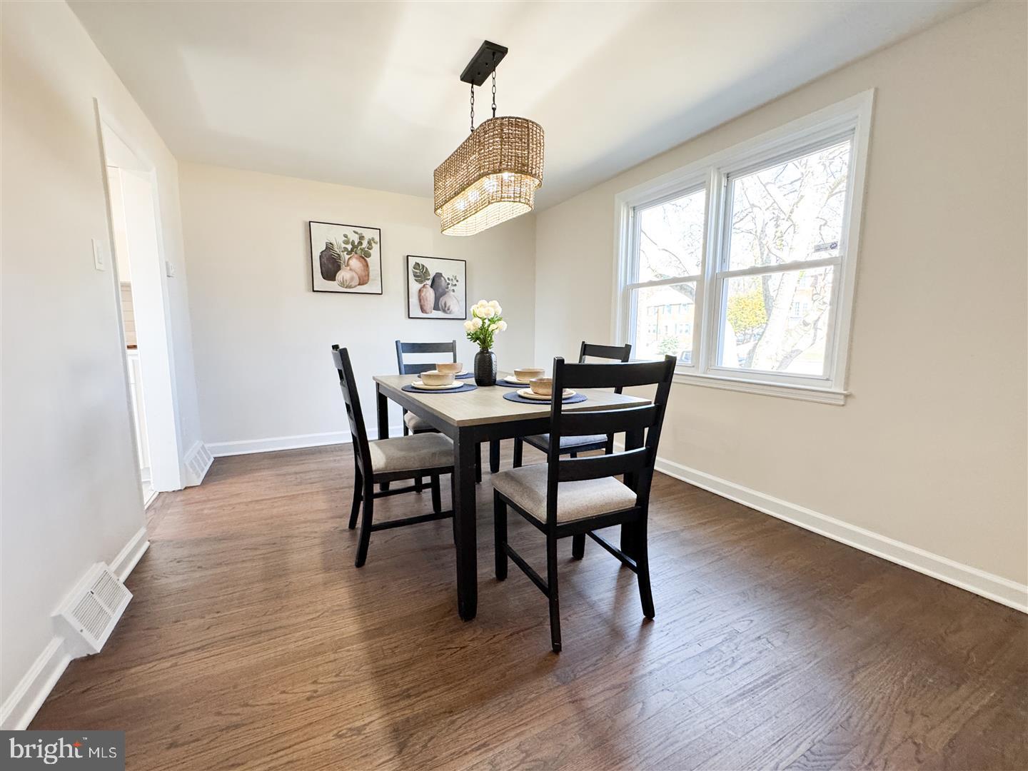 260 Gibbons Road Springfield, PA 19064 - Photo 8 of 31 a dining room with wooden floor a chandelier a wooden table and chairs