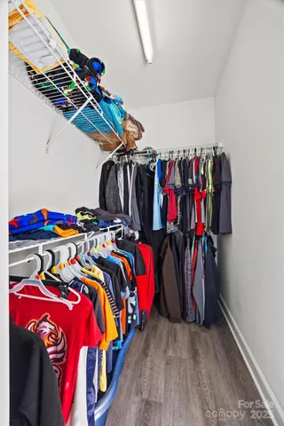 a view of walk in closet with clothes and shoes