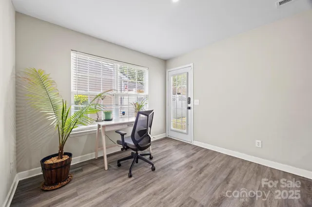 a view of a workspace with furniture and a window