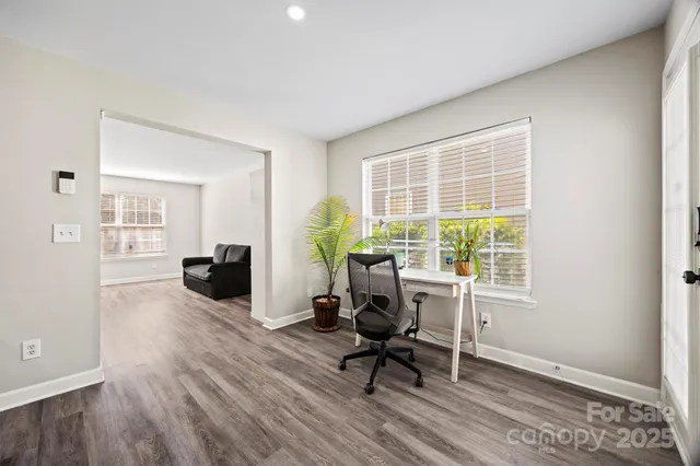 a view of a livingroom with workspace and a window