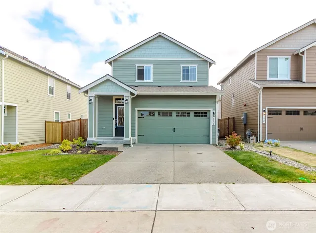 a front view of a house with a yard and garage
